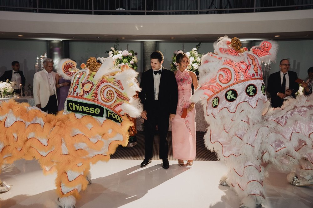 Two lion dancers flanking the couple as they enter the banquet