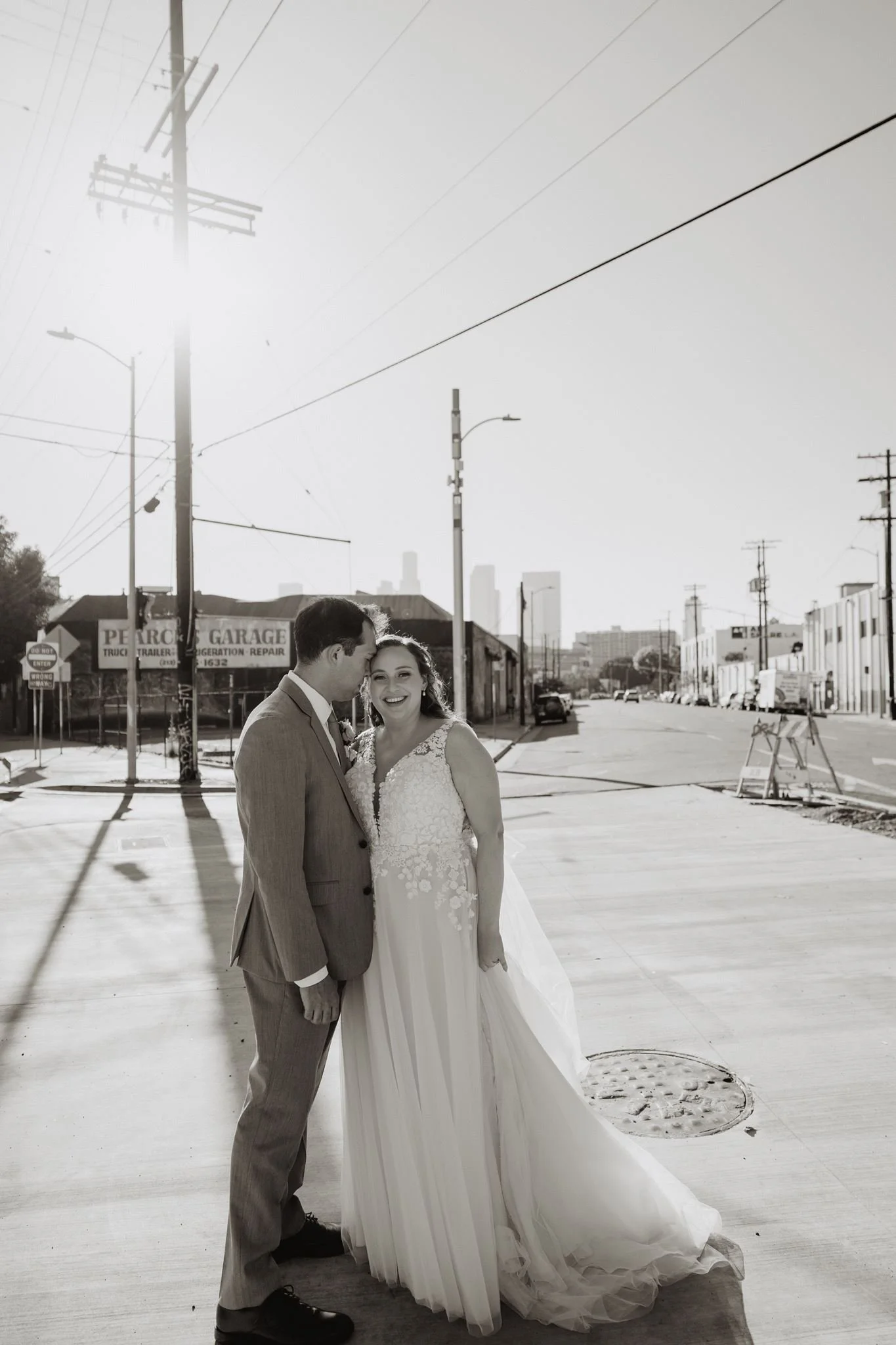 Couple on the sunlit Arts District sidewalk outside Millwick, black and white