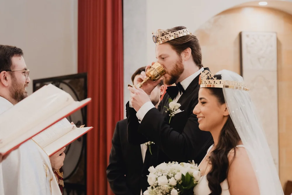Crowned bride and groom sharing the common cup during an Armenian wedding ceremony