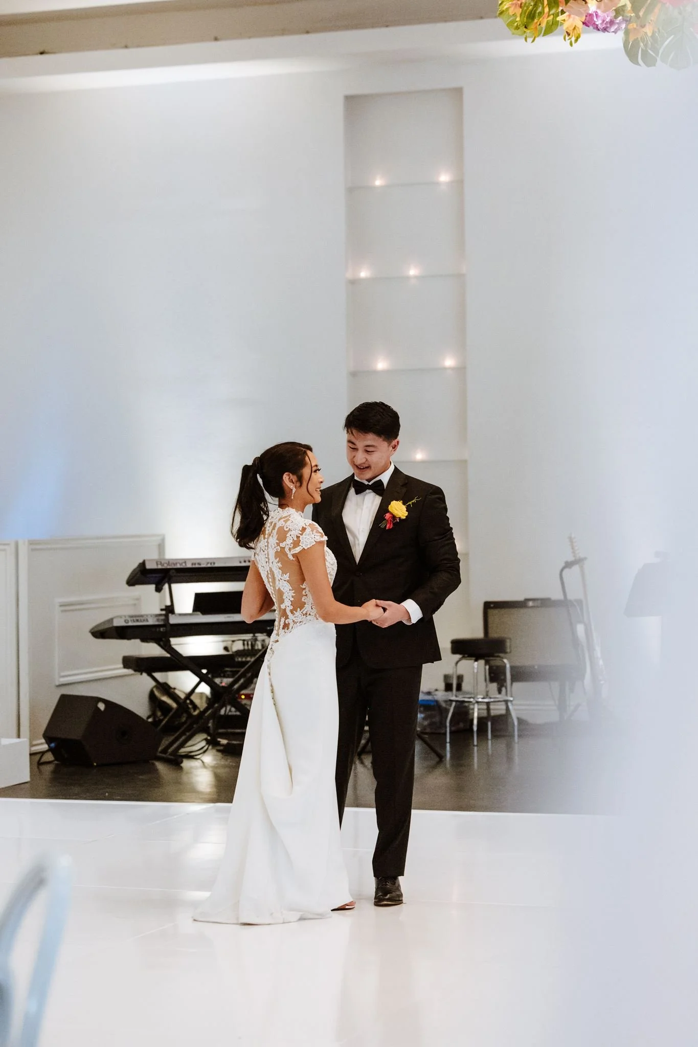 Couple on the white floor of the bright reception room at Venue by Three Petals