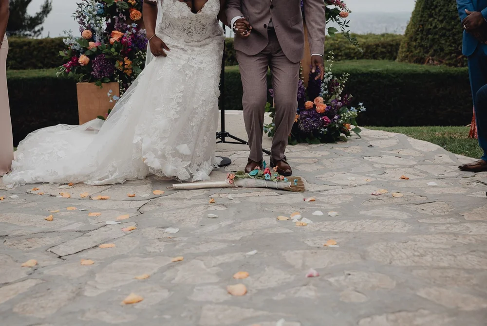 Couple jumping the broom on the stone ceremony circle at La Venta Inn