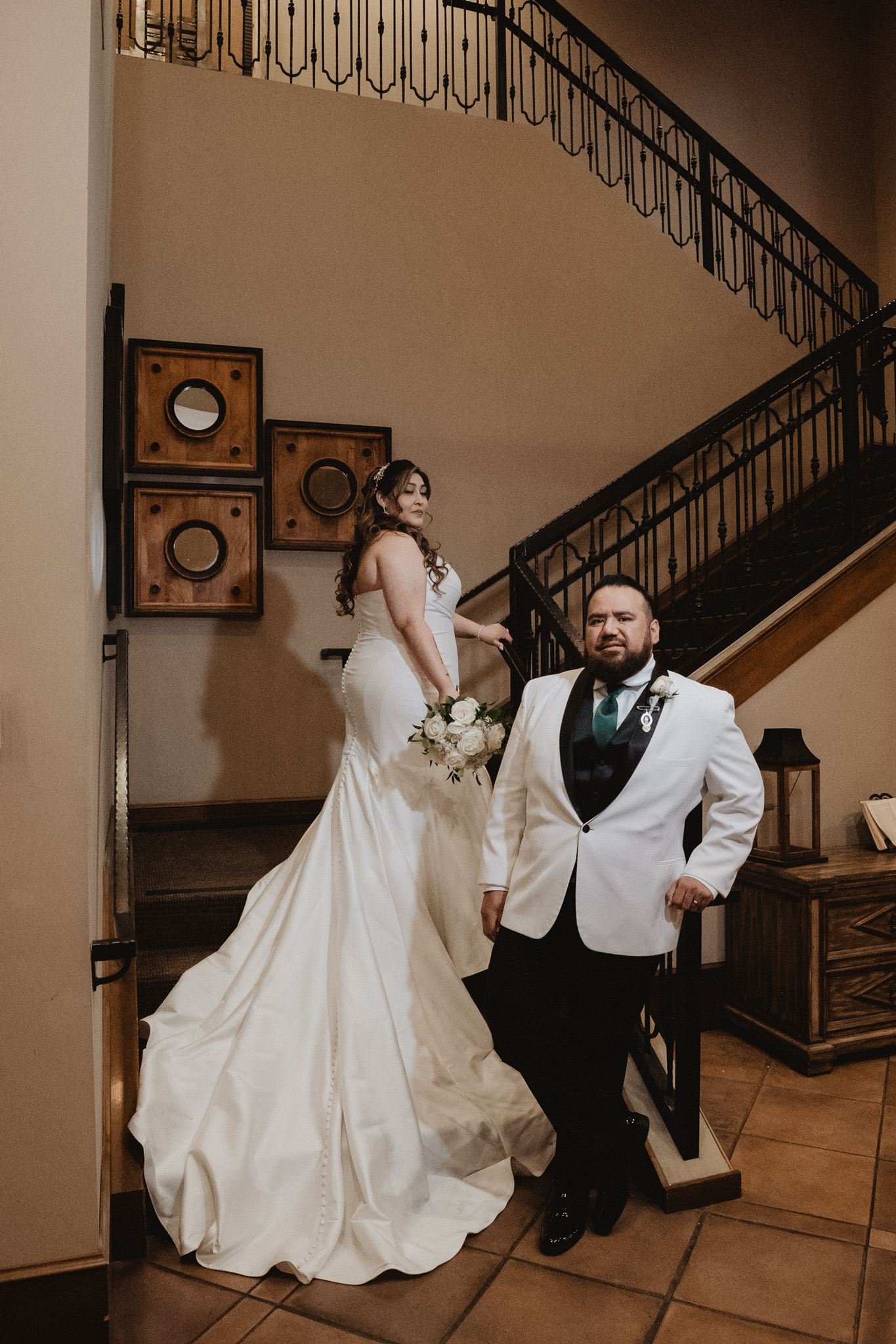 Couple at the foot of the wrought iron staircase inside Vellano Estate