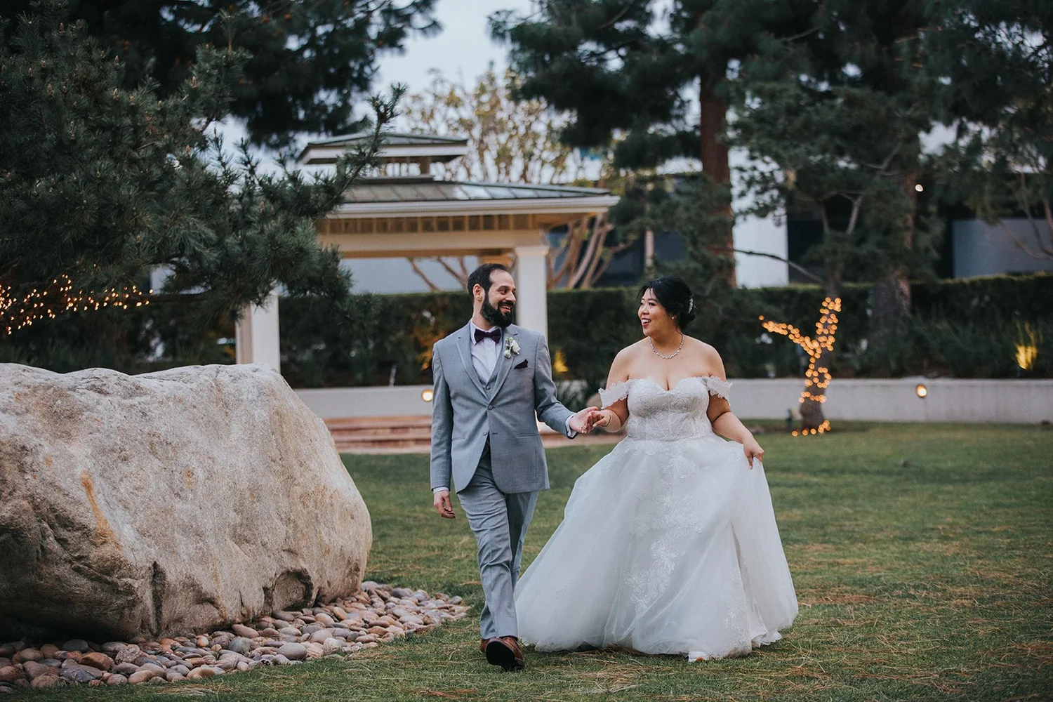 Couple photographed beside a stone feature in the gardens at Turnip Rose Promenade