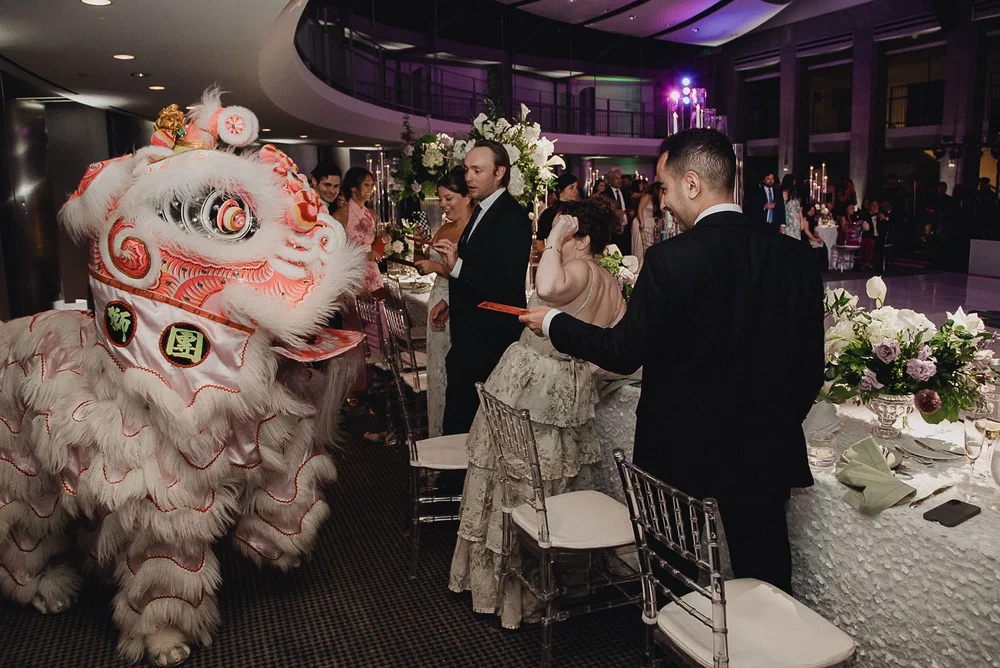 Lion approaching the couple at their sweetheart table to receive the red envelope