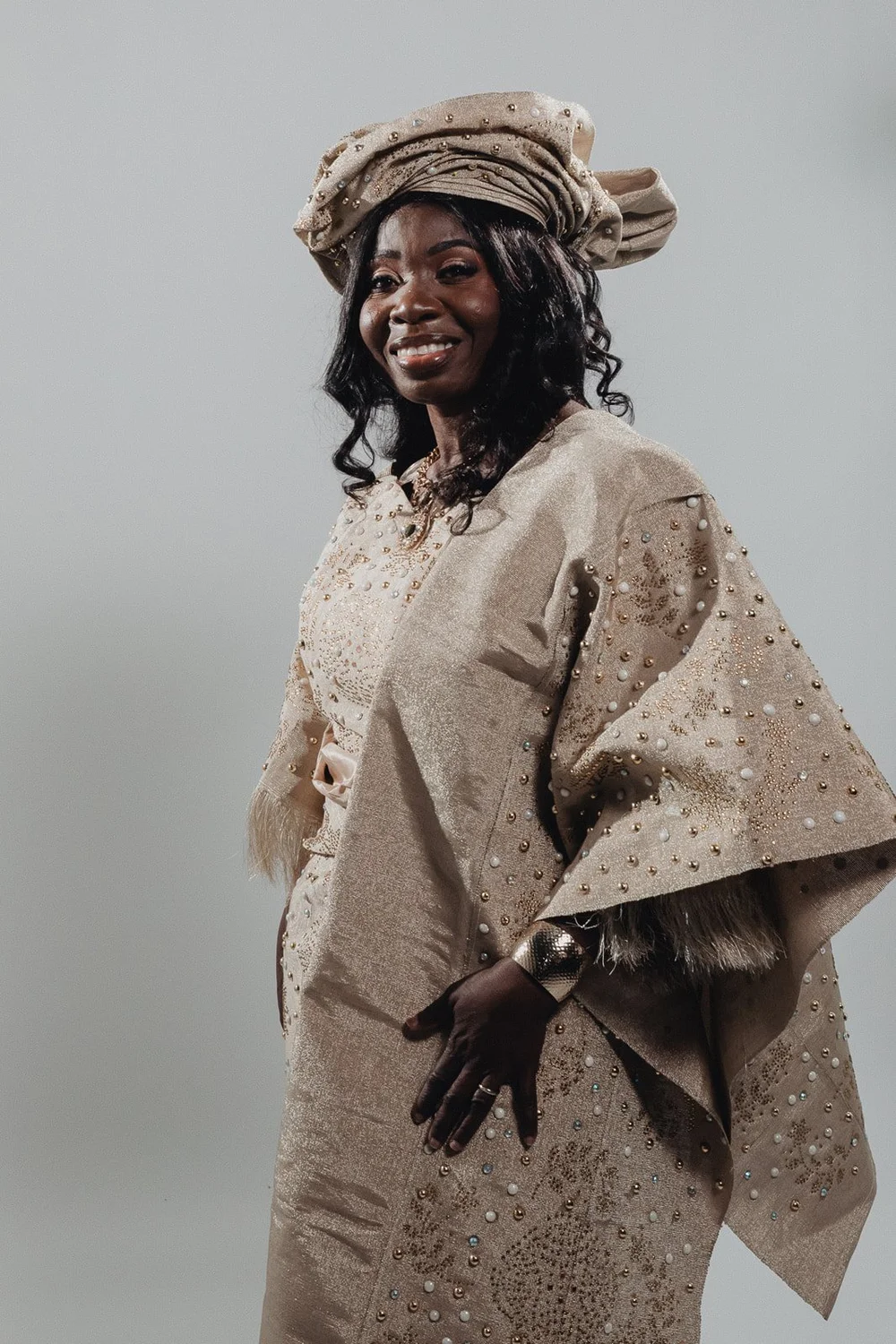 Portrait of the bride in a pleated gele and a pearl-beaded buba with a fringed shawl