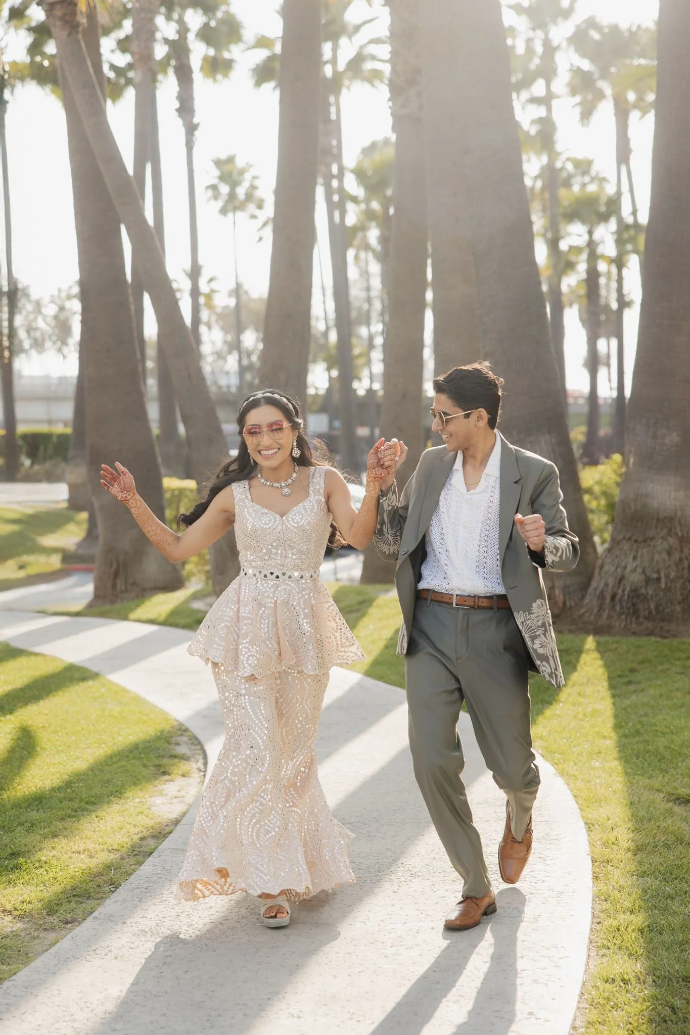 Couple walking the curved path under tall palms at Hotel Maya, Long Beach