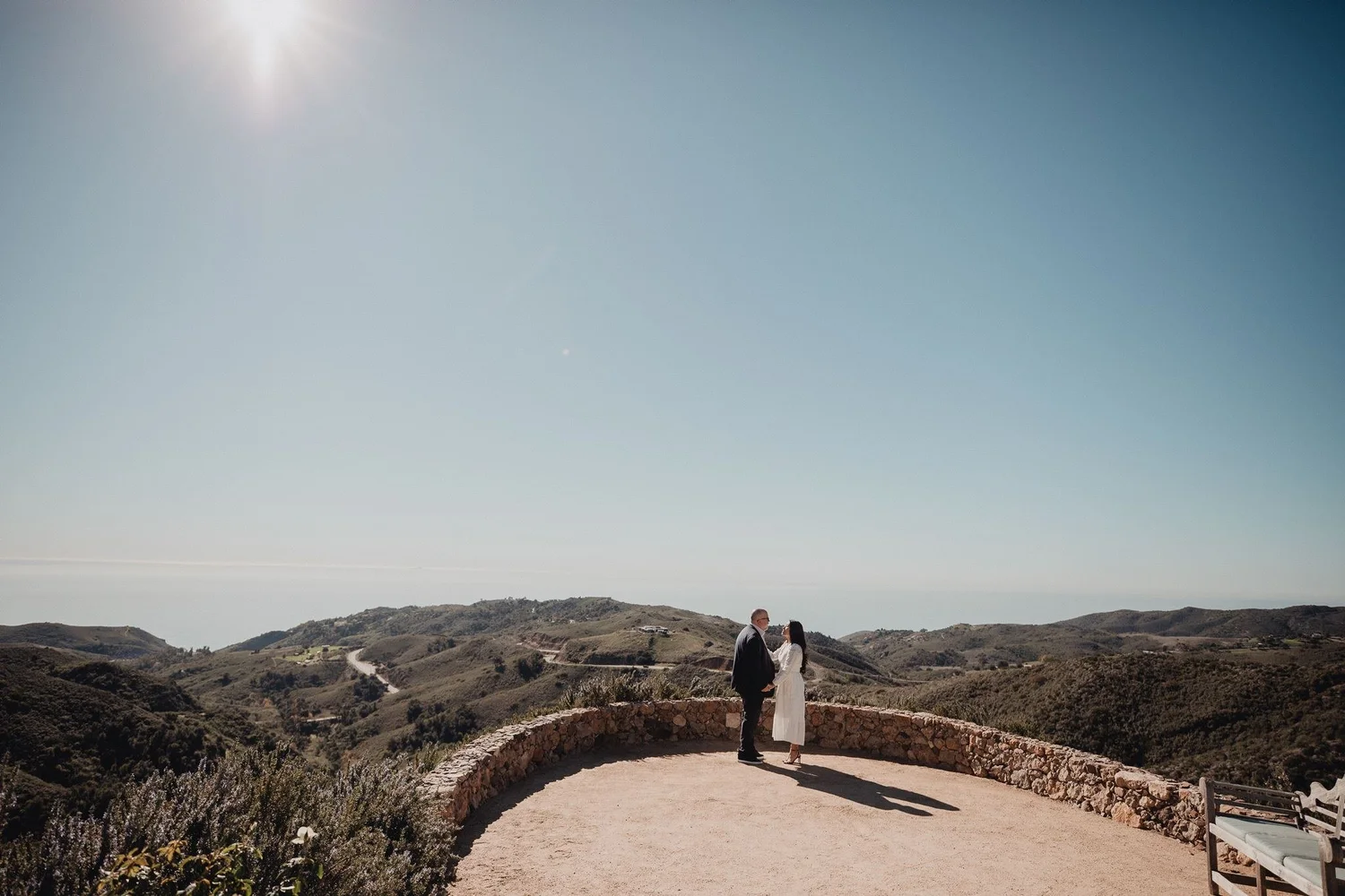 Couple on a stone overlook above the Malibu hills at a private ranch