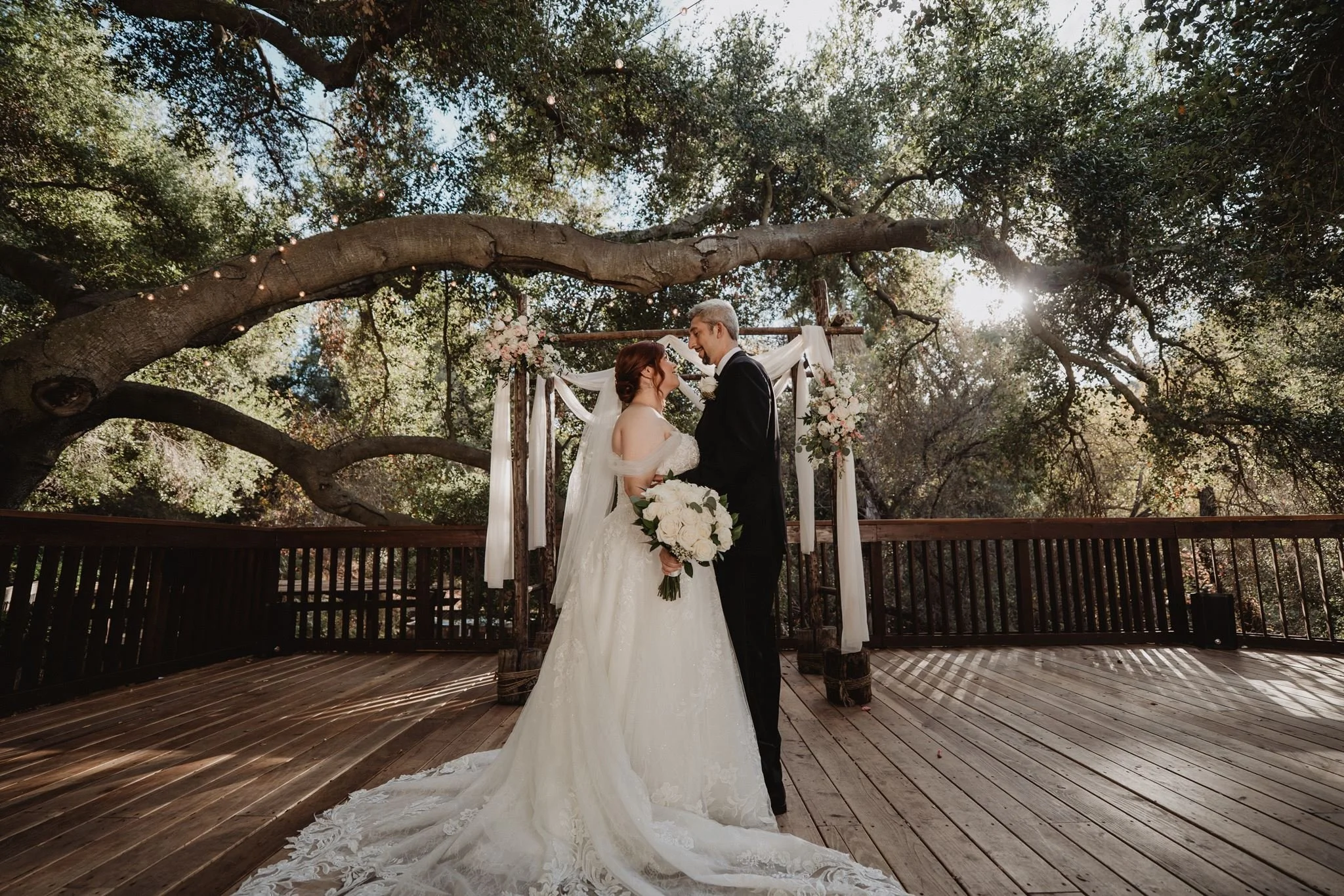 Couple on the wooden deck under a spreading oak canopy at The 1909 in Topanga