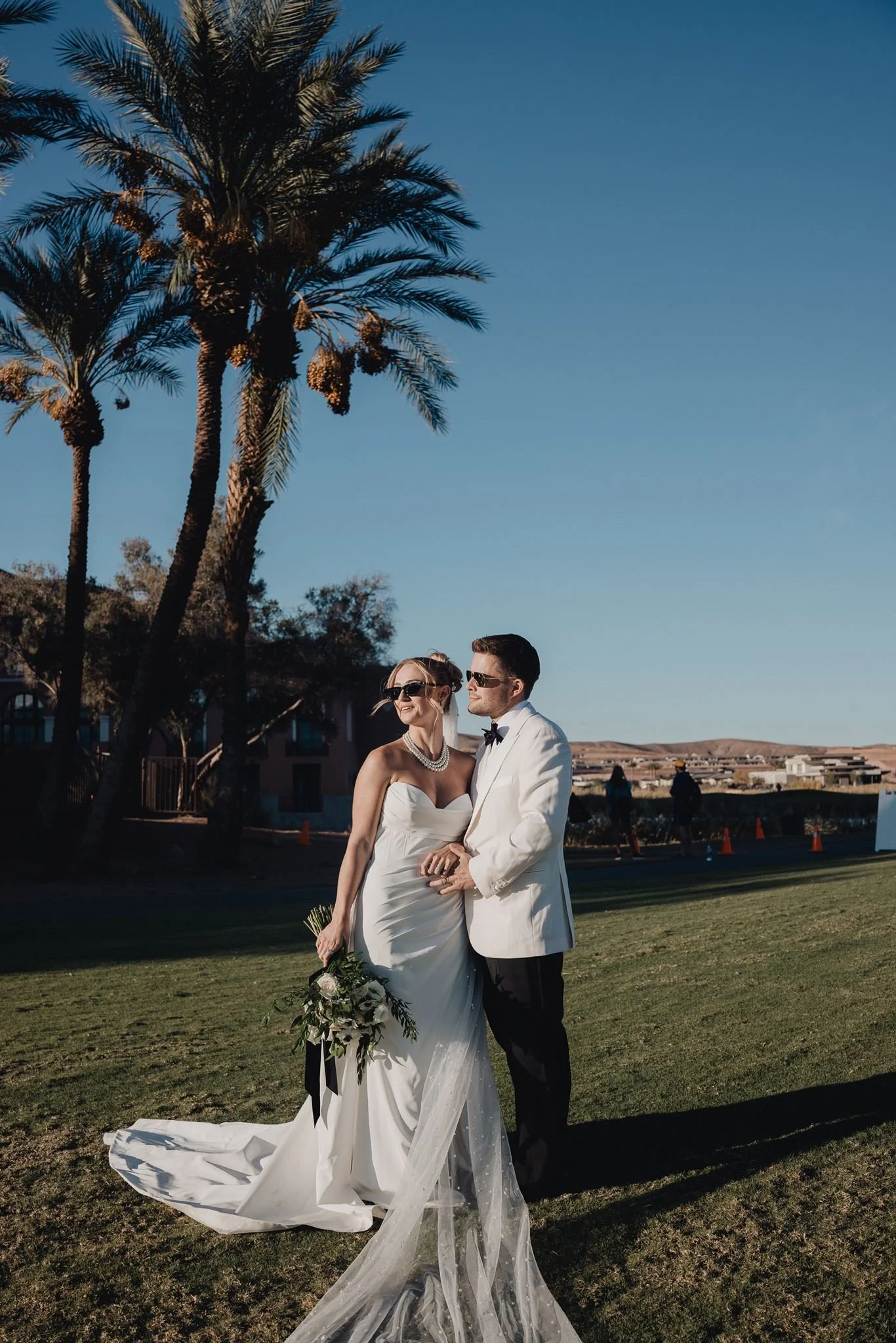 Couple on the lawn under tall palms with desert hills beyond at Westin Lake Las Vegas