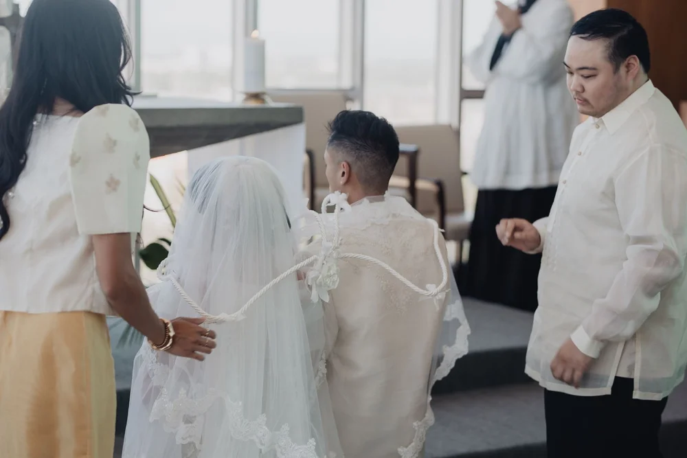 Secondary sponsors laying the yugal cord in a figure of eight over the couple