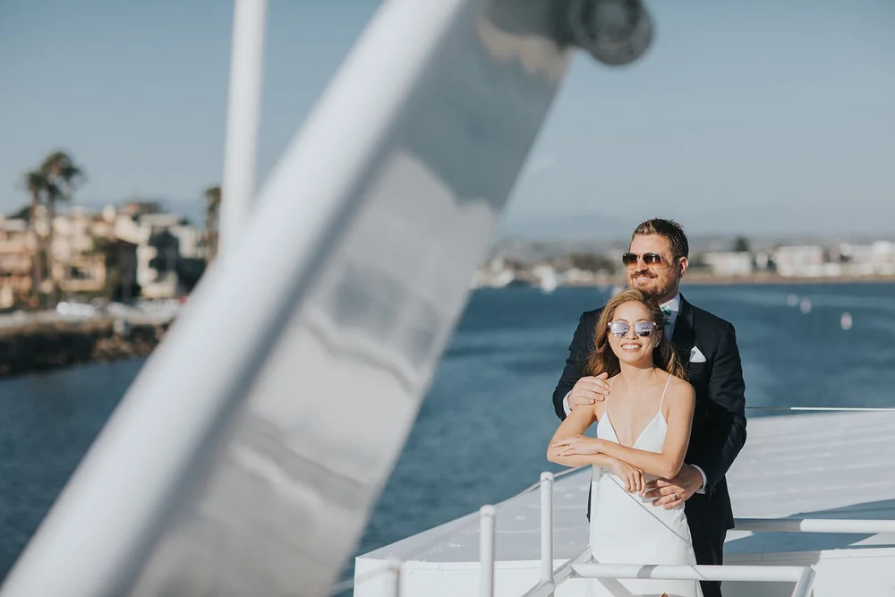 Couple in sunglasses at the rail of a FantaSea yacht in the Marina del Rey harbor