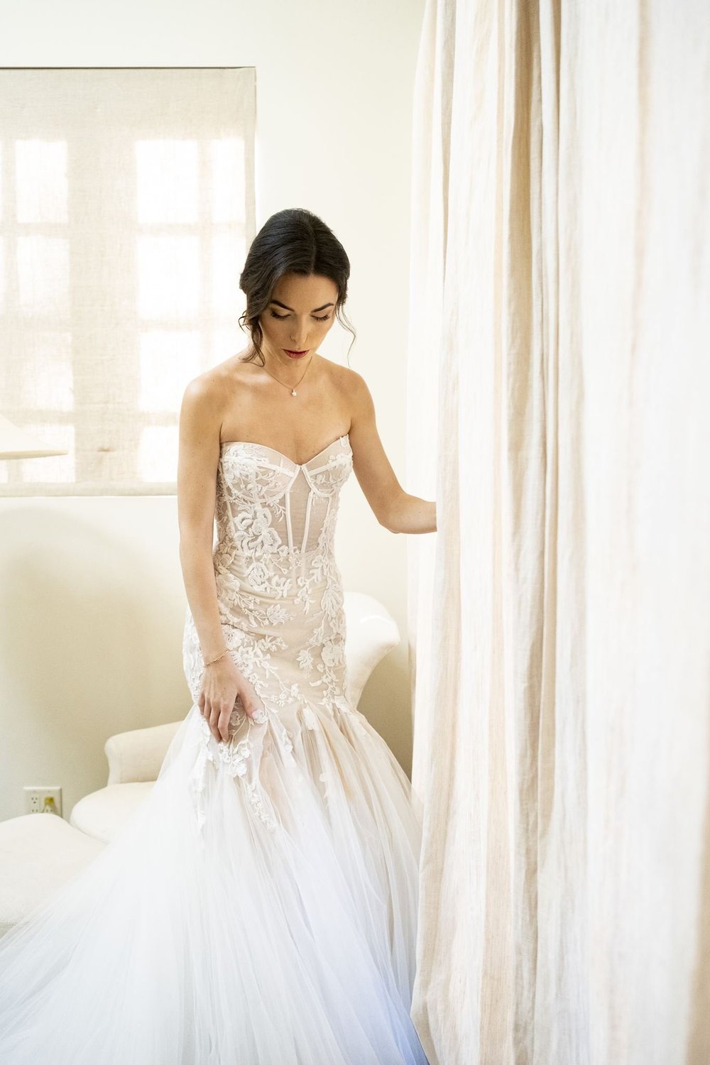 Close portrait of a bride in a corset wedding gown with visible vertical boning across a beaded bodice
