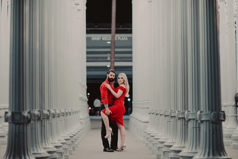 Couple in red among the lamp posts of Urban Light at LACMA