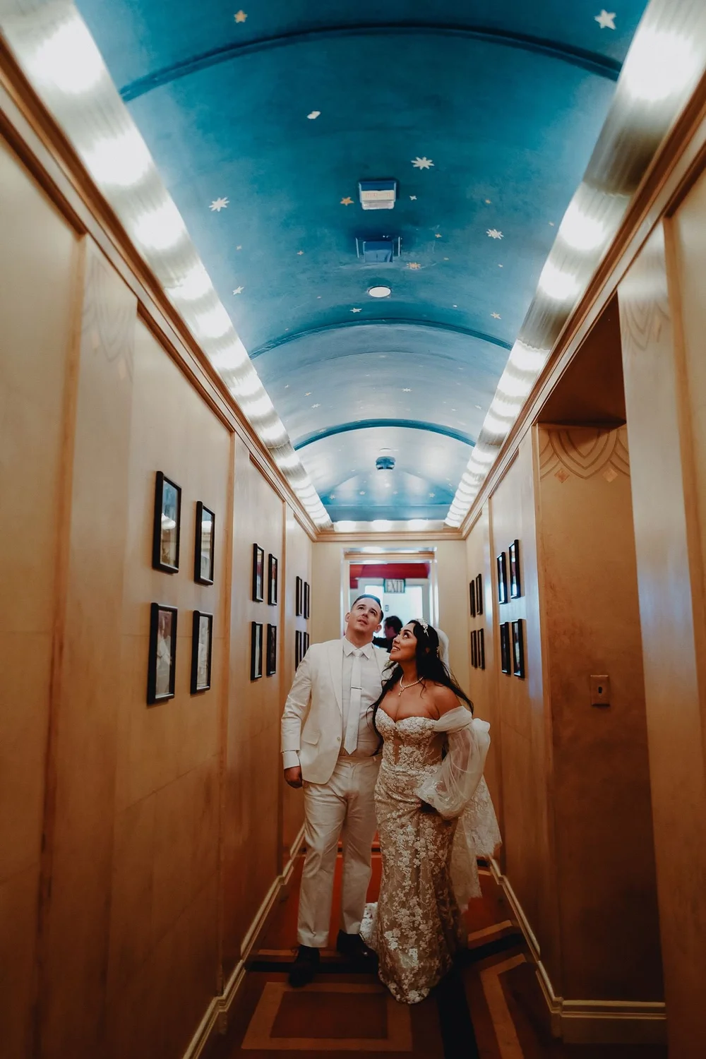 Couple sharing a quiet moment beneath the illuminated glass cornice of the Art Deco Oviatt Penthouse in Downto