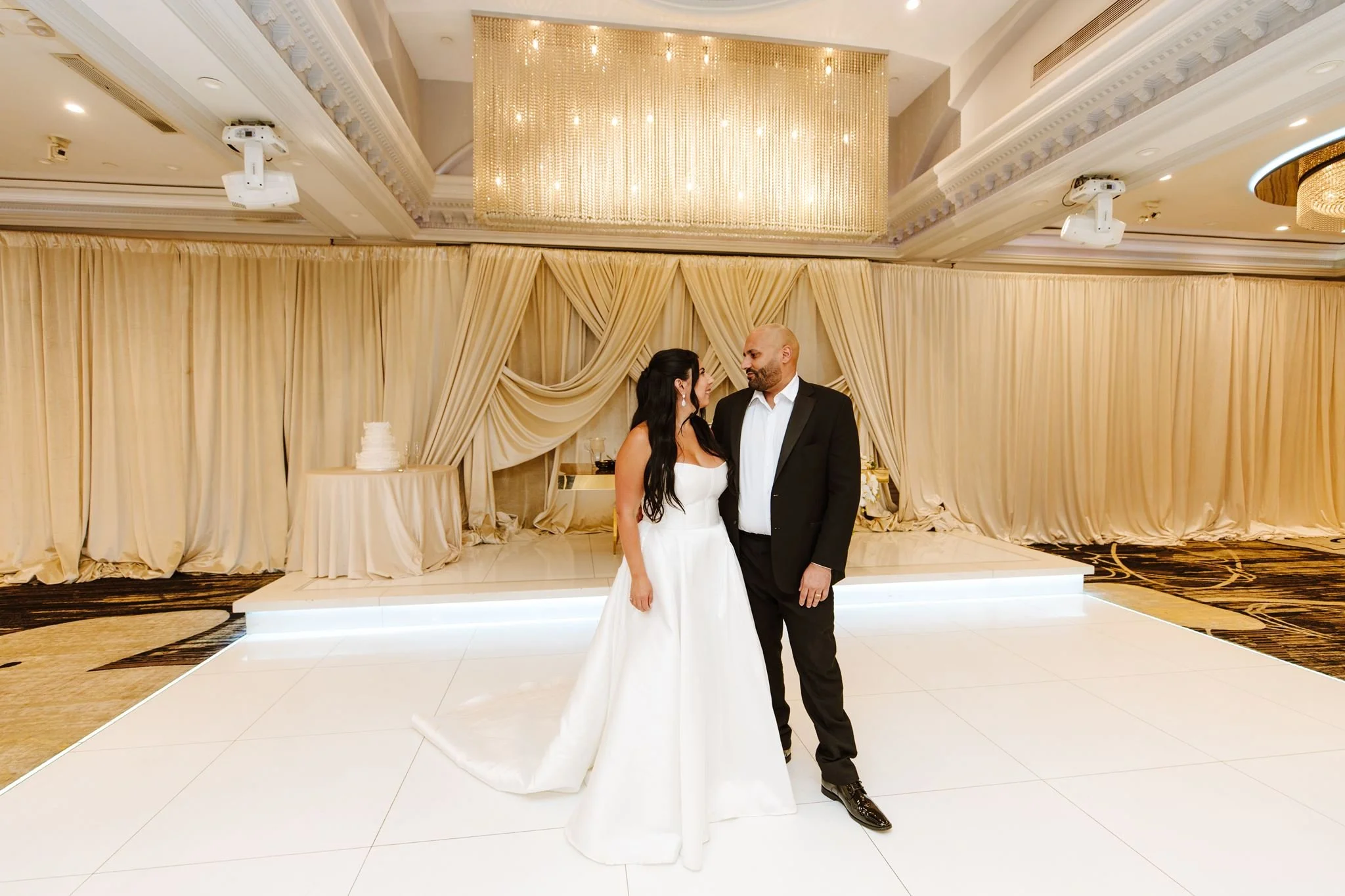 Couple on the white dance floor of the draped ballroom at Glenoaks Ballroom in Glendale