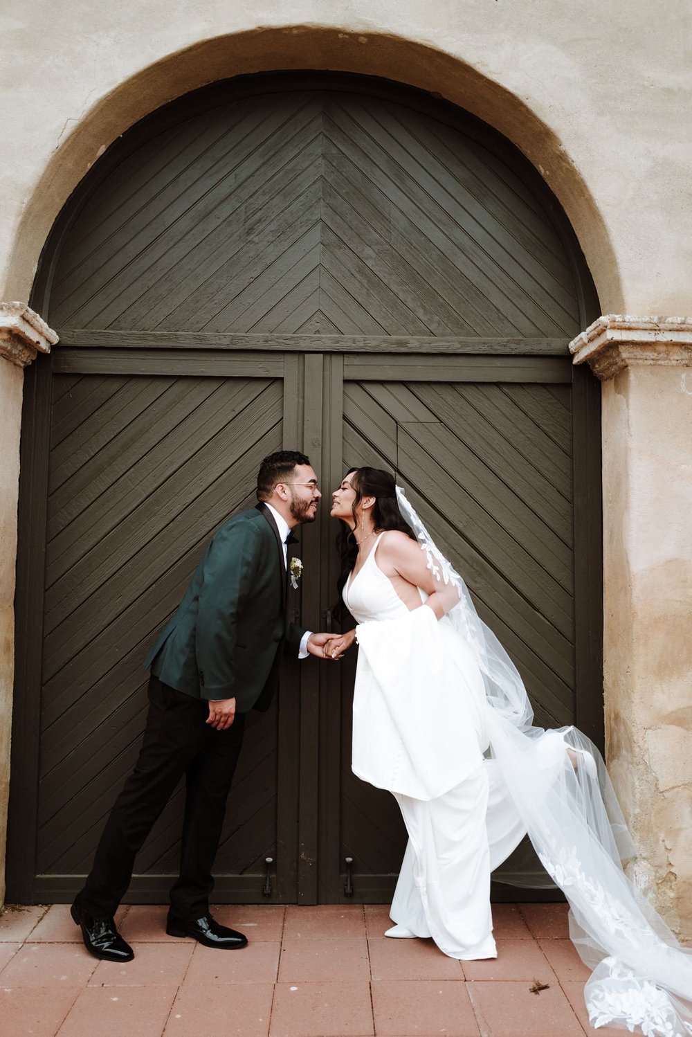 Wedding portrait at the entrance of Mission San Gabriel Arcangel