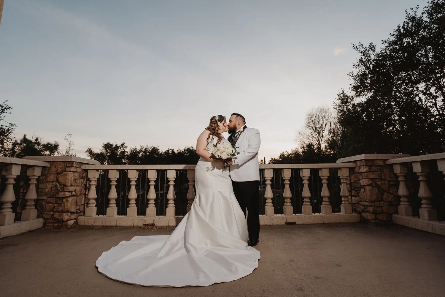 Couple on the balustraded terrace against the evening sky at Vellano Estate