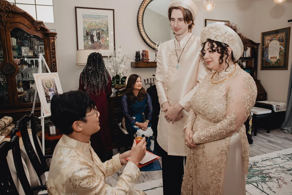 Elder receiving a cup of tea from the couple in the family living room