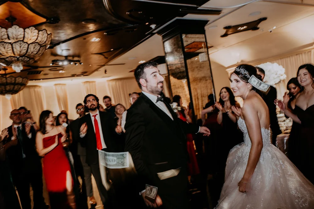 Guests showering the groom with bills as the couple dances at an Armenian wedding reception