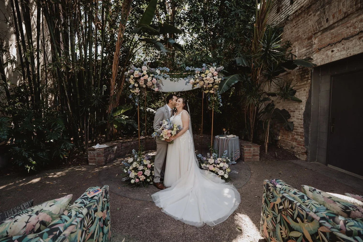 Couple among tall bamboo and plants in the courtyard at Millwick, Los Angeles