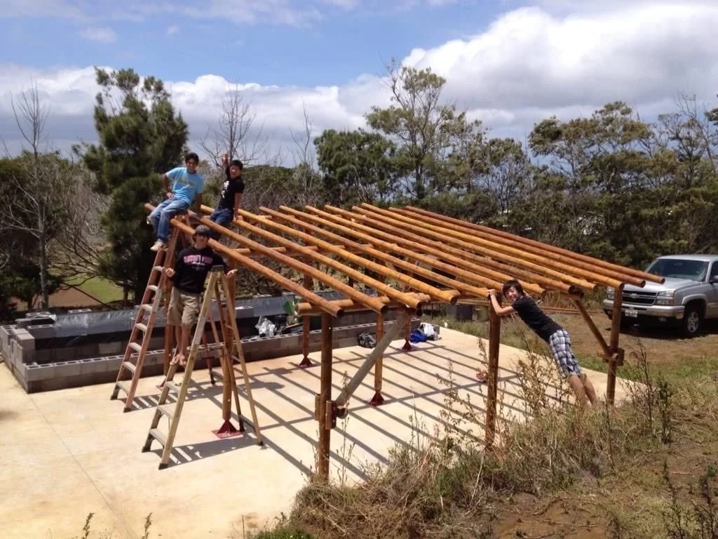 Four students celebrating on the completed bamboo frame
