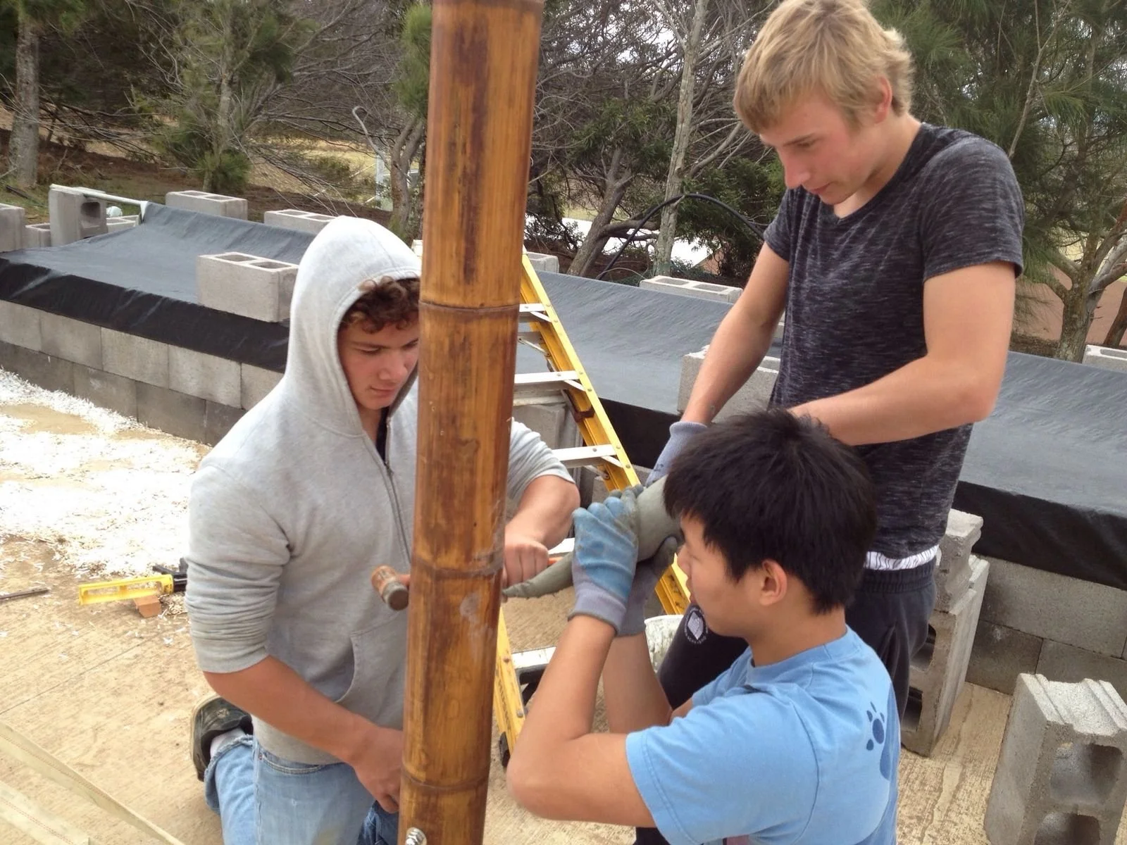Three students working a bamboo joint