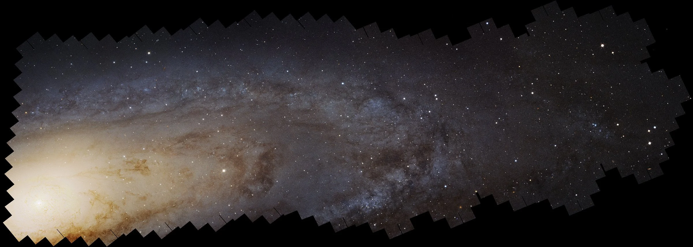 Hubble photomosaic of the Andromeda Galaxy, with a bright central core, blue outer disk, dark dust lanes, and jagged mosaic boundaries.