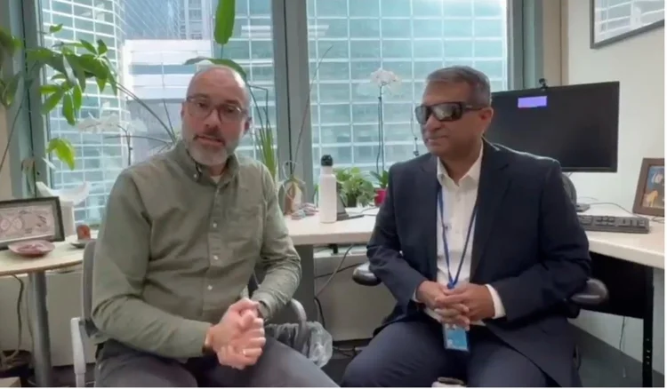 A screen shot photo, from the video, of Gopal Mitra with UNICEF head of communications sitted in their office 