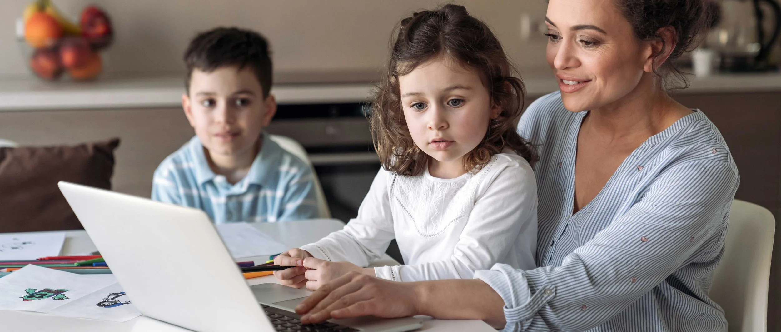 Parent and children looking at a laptop together