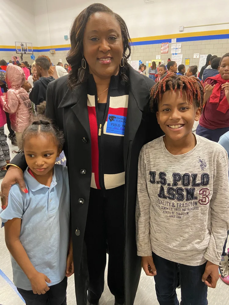 Lady Gail Booker with two young people at a community gathering