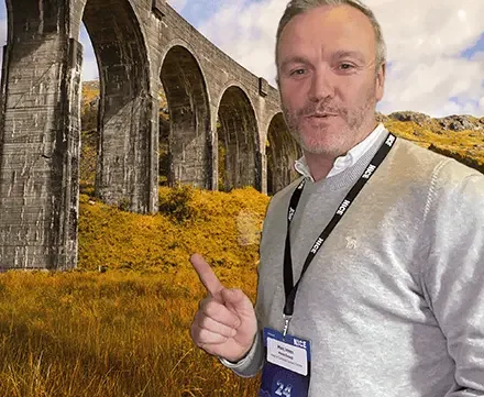 AI green screen experience hire Glasgow — corporate event guest transported to the Glenfinnan Viaduct using AI background removal by Social Jungle