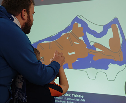 Digital graffiti wall hire — fans creating branded artwork on an interactive touchscreen at a sporting event by Social Jungle