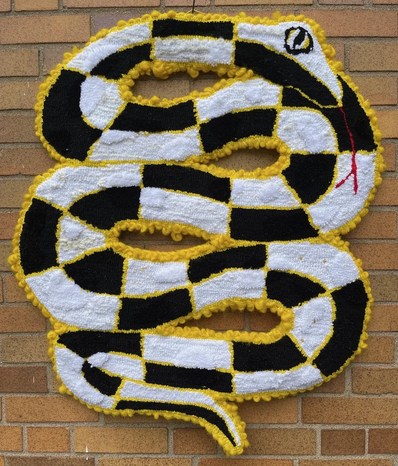 Coiled black, white, and yellow serpent rug