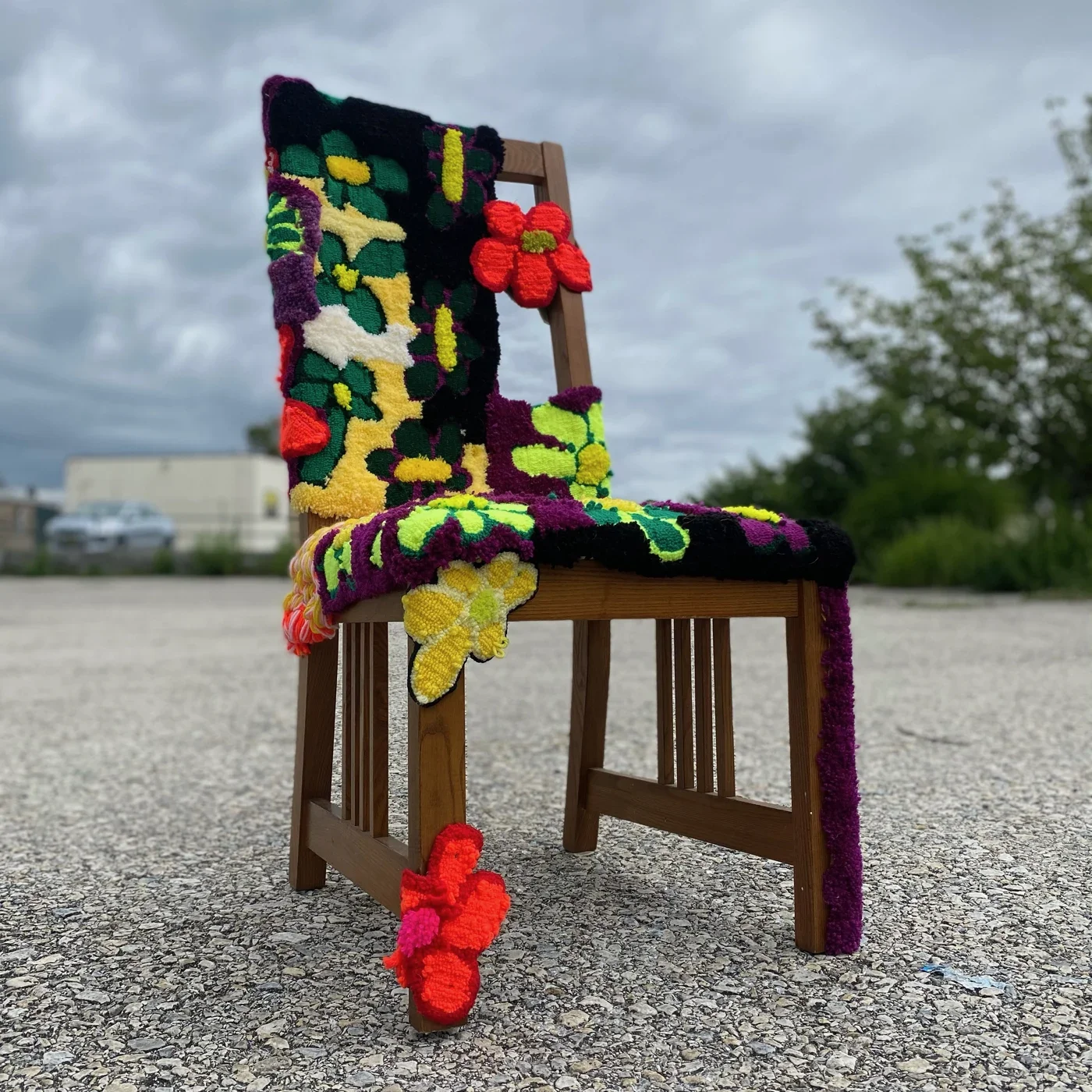 Wooden chair covered in colorful textile flowers