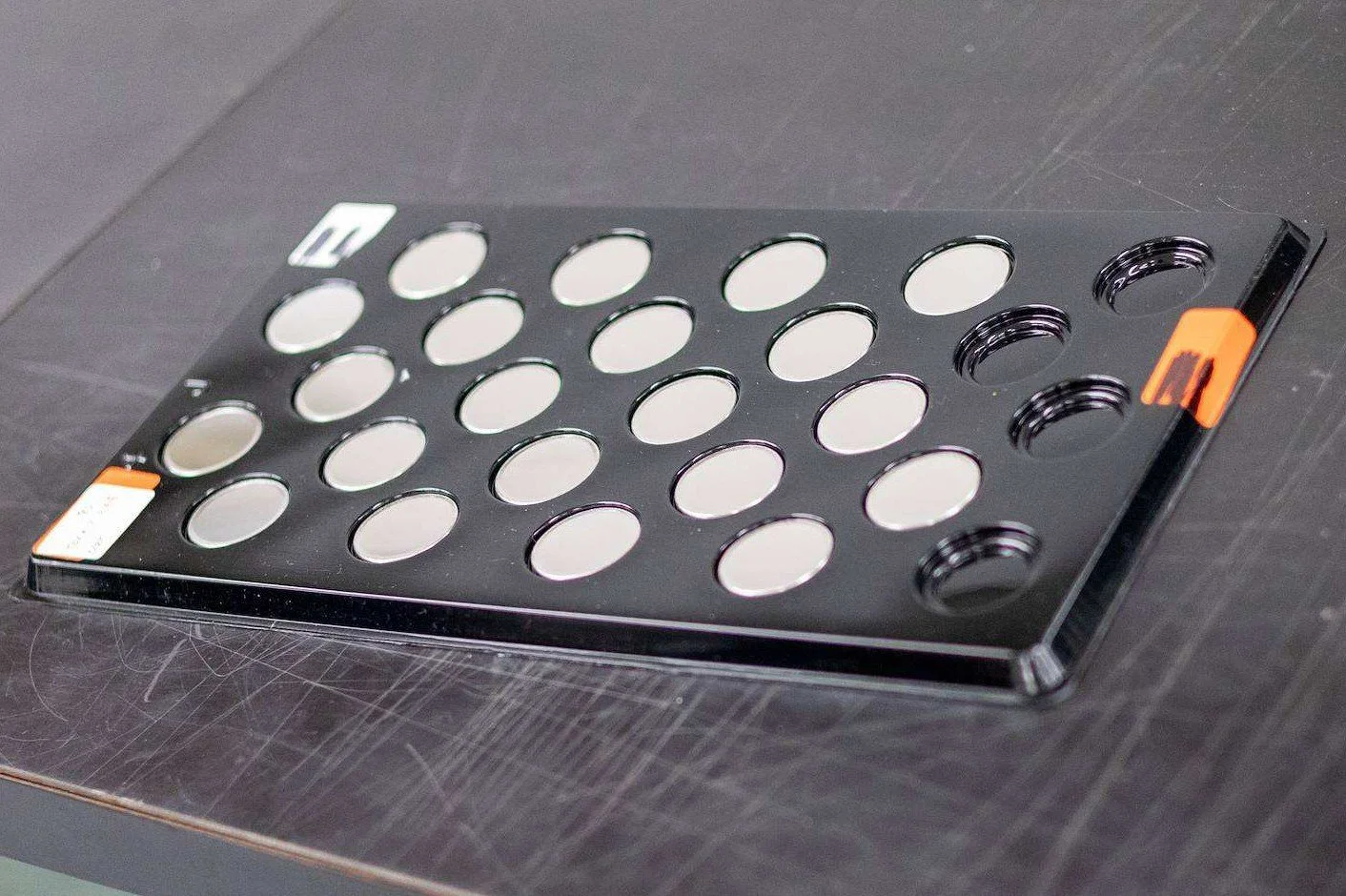 Tray of precision-blanked round metal discs awaiting inspection