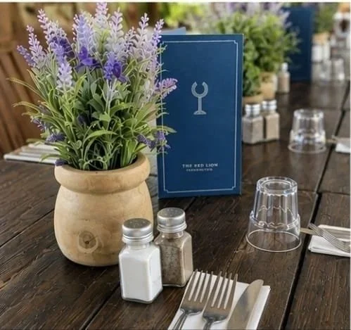Lavender in a pot beside a menu and salt and pepper on a terrace table