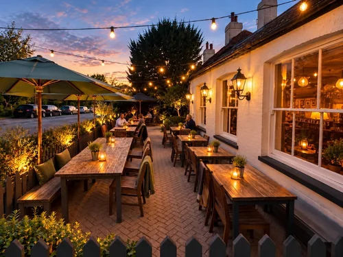The terrace at dusk under festoon lights, with candles on the tables