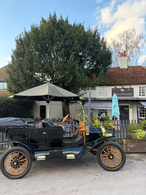 A vintage car parked outside the pub