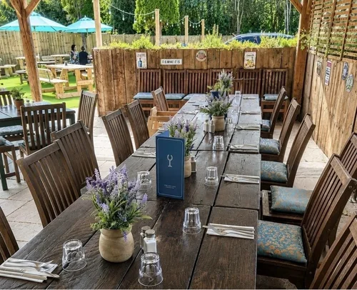 A long table on the covered terrace laid with lavender, menus and glasses