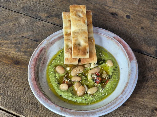 A starter with crisp bread and a vibrant herb purée