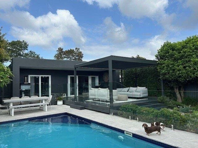 Louver pergola beside a pool