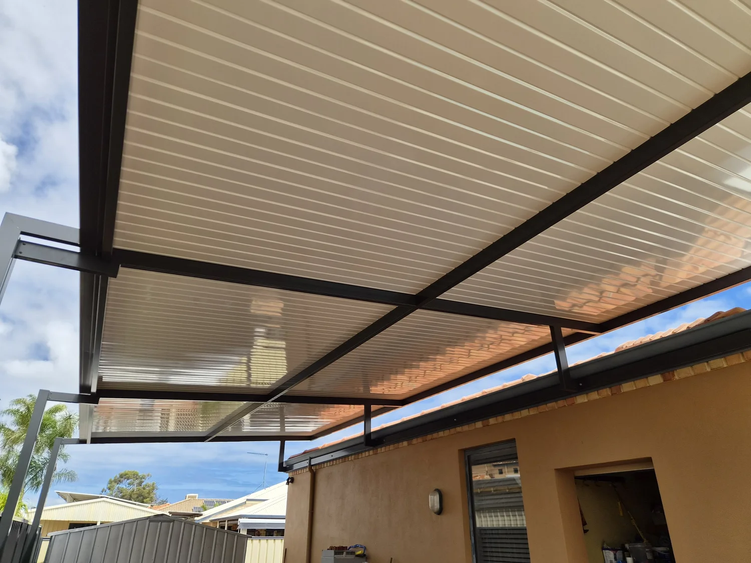 Flyover patio frame extending above the existing roof