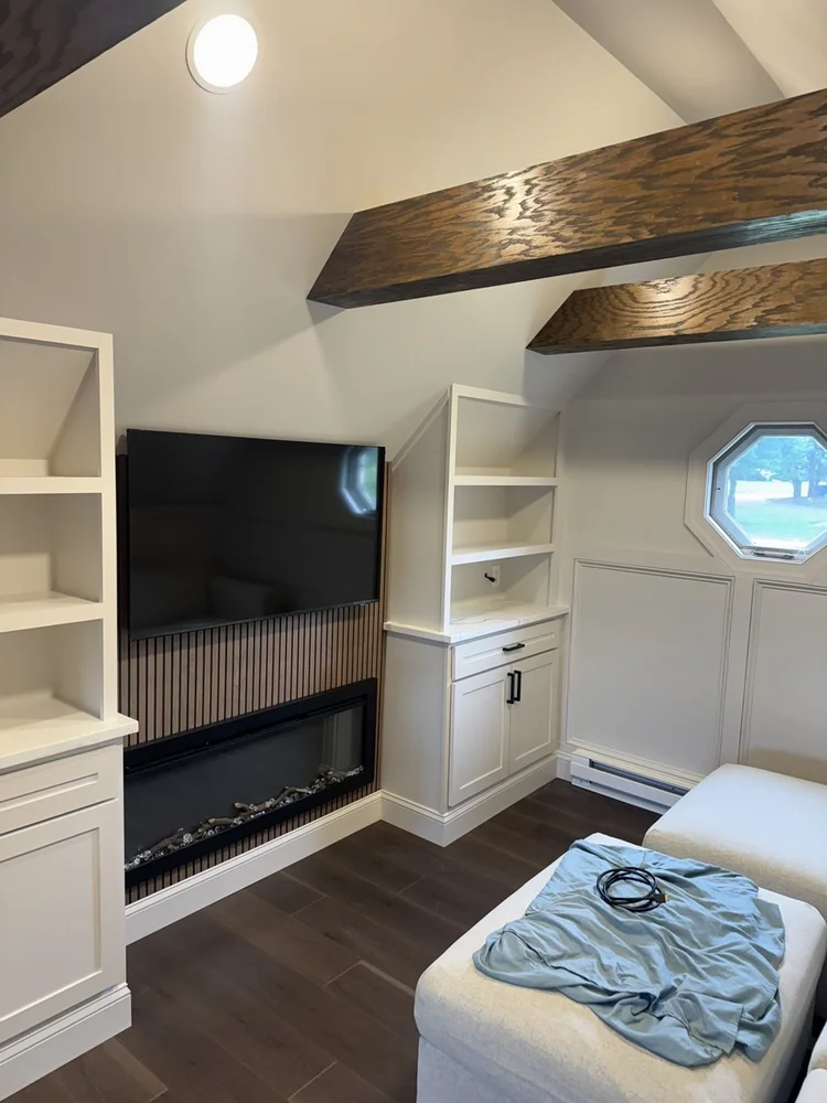Electric fireplace with natural oak slat wall and TV – Hilltown, PA attic playroom