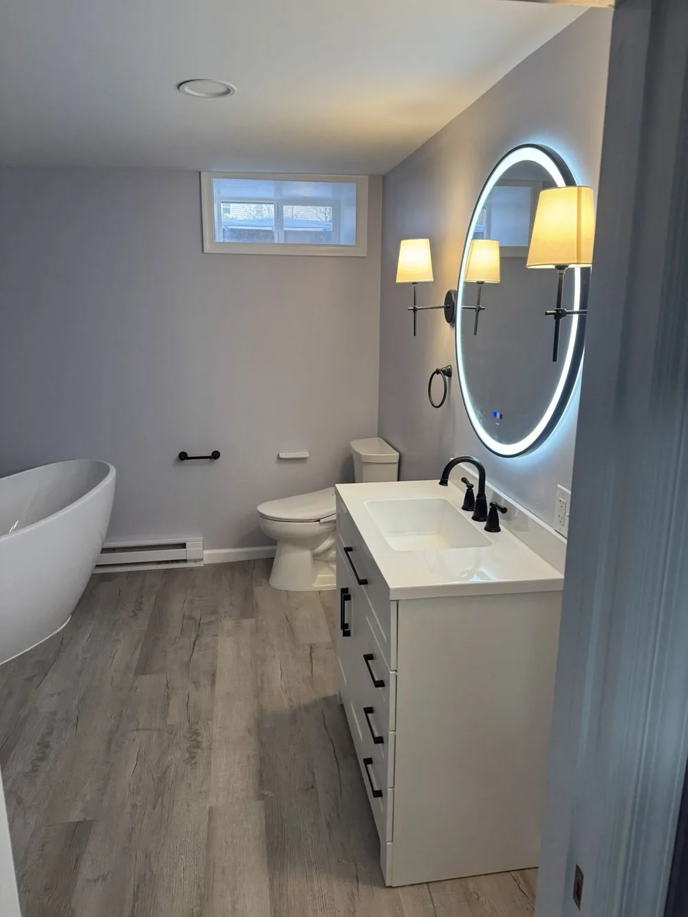 North Wales, PA finished basement bathroom with LED mirror vanity and freestanding tub