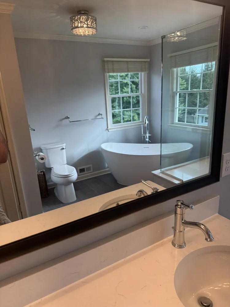 Mirror view of the tub, toilet and charcoal tile floor – Hatfield, PA primary bathroom remodel