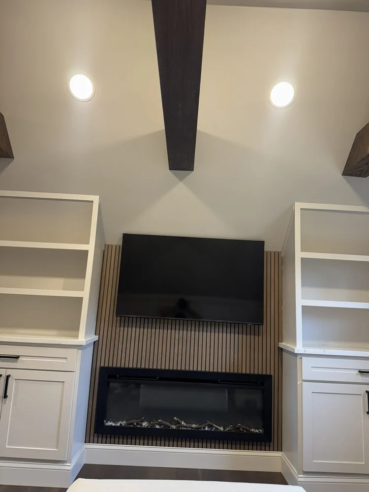 Oak-wrapped beams and recessed lighting above the fireplace wall – Hilltown, PA attic playroom