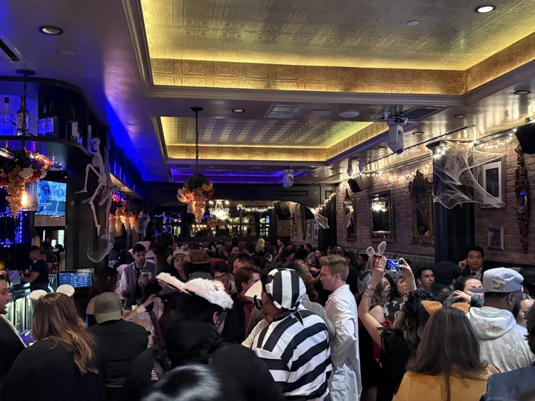 A packed Halloween night at Hudson Social, guests in costume