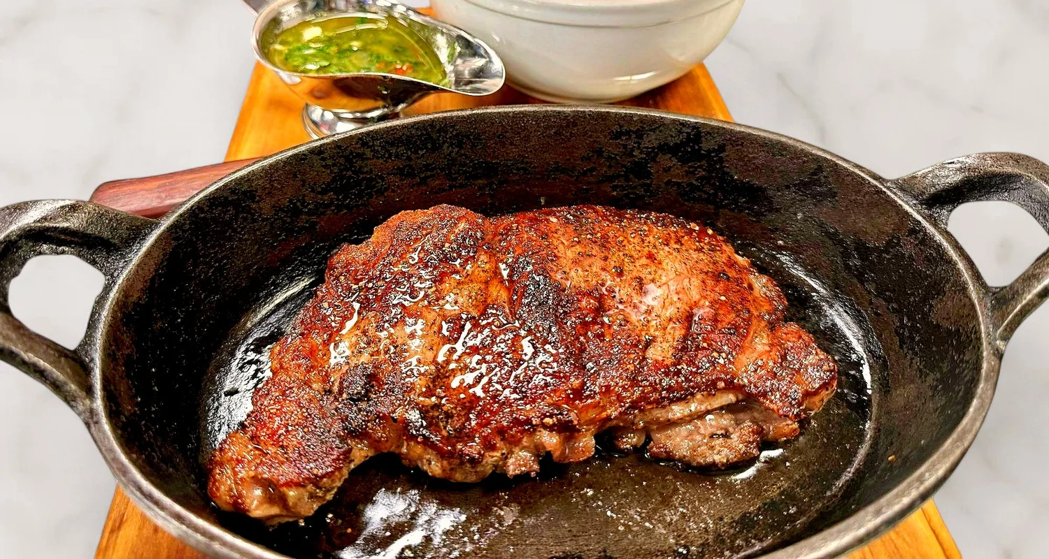 NY strip steak in a cast-iron pan at Hudson Social