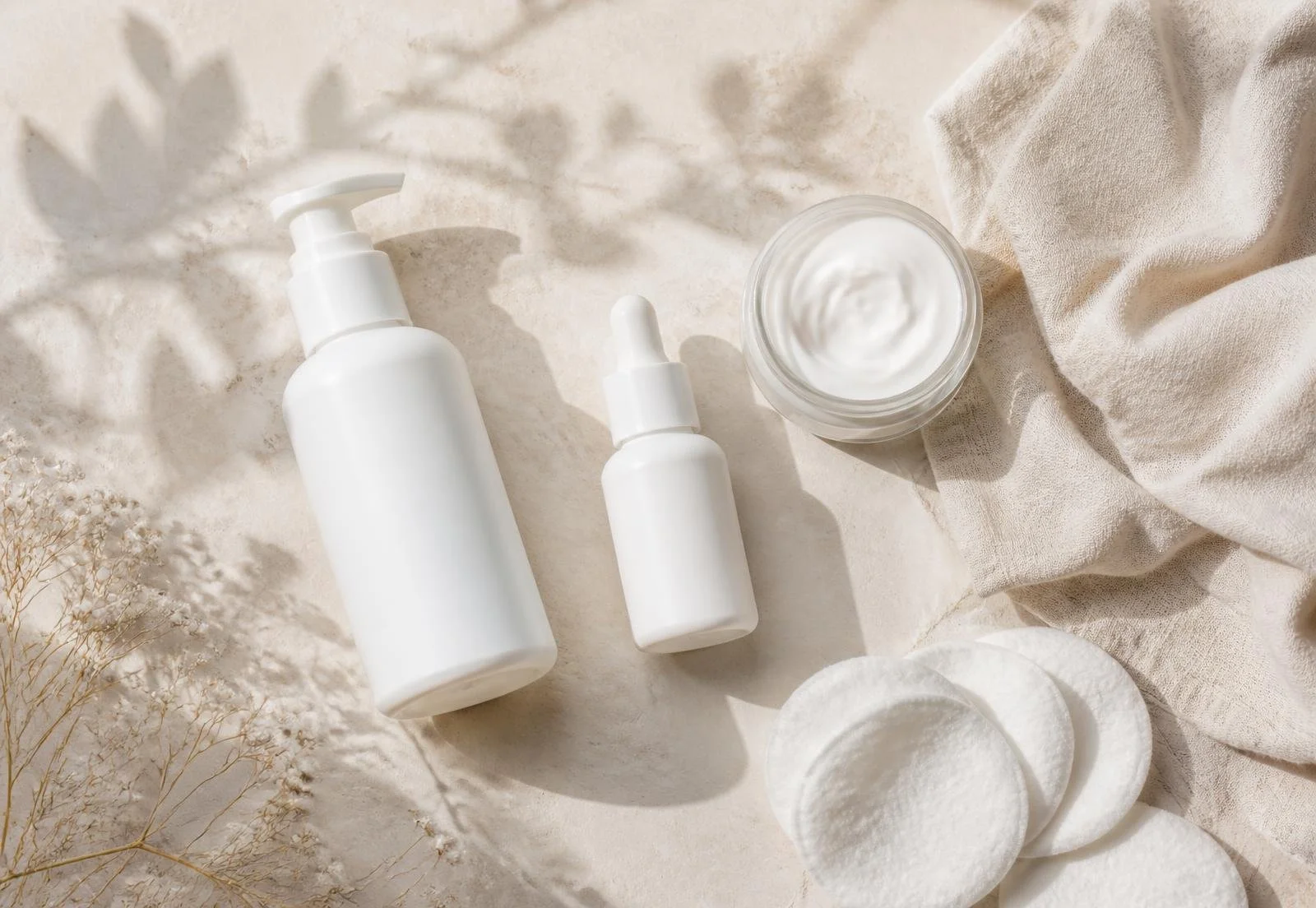 Gentle unbranded cleanser, serum and moisturiser laid out for post-laser skincare