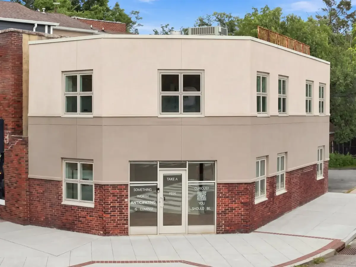 The Anticipated Events building on a Bloomfield corner, with storefront windows reading Something Worth Anticipating Is Coming